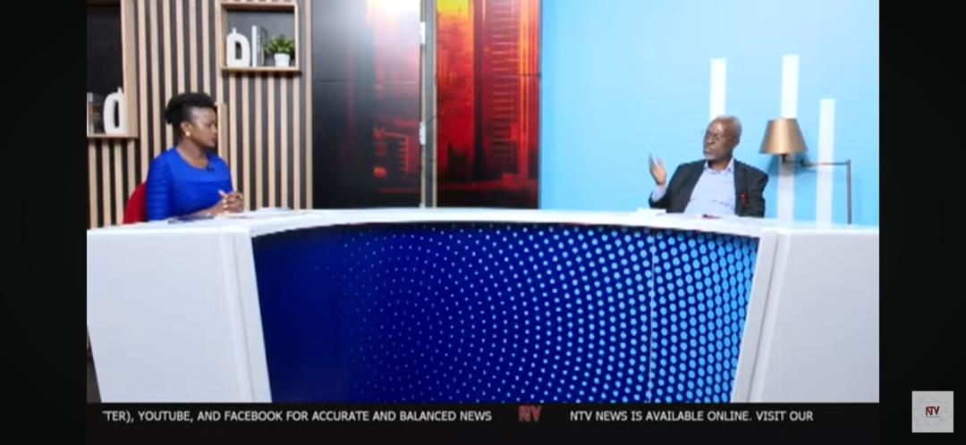 A photo containing a black woman interviewing a black man with a disability in a studio setting