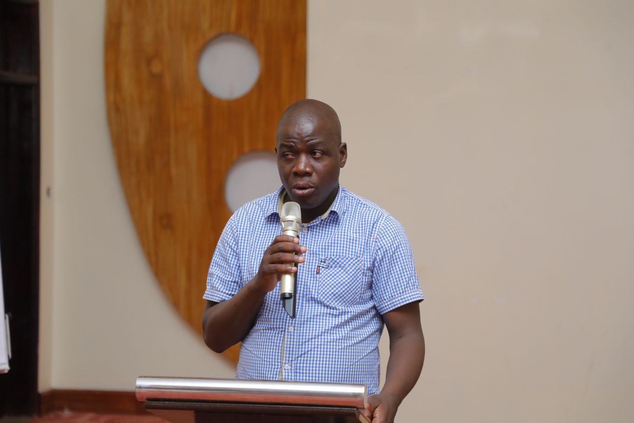 A black man with a disability addressing the crowd in a meeting